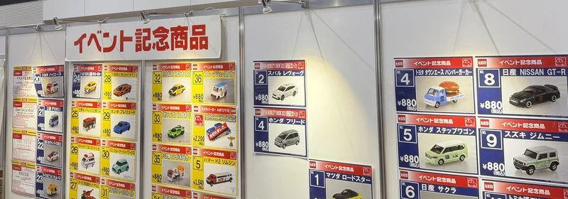 トミカ博2026の物販エリアに掲示されたイベント記念商品リスト。880円均一で番号付き